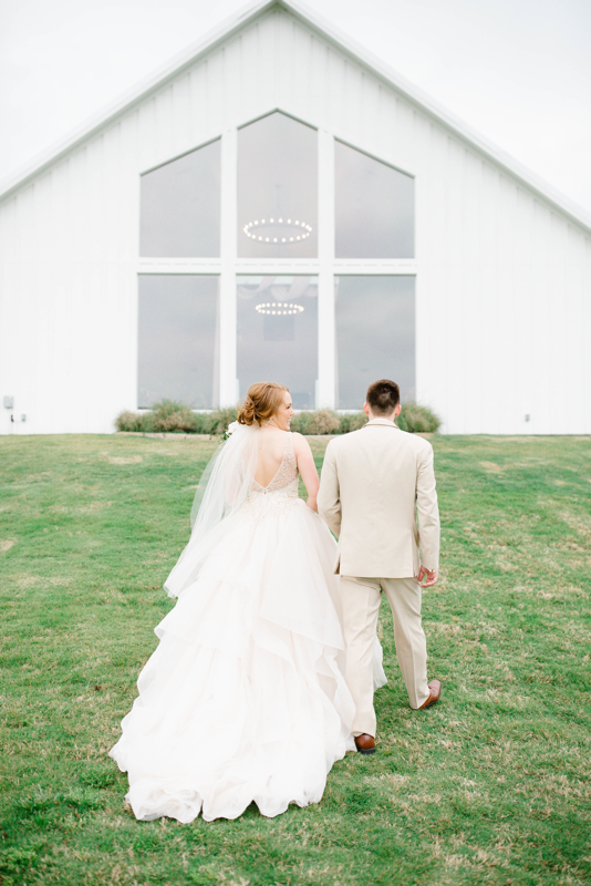 Bride and groom holding hands. bride and groom walking. Farmhouse wedding. Farmhouse montgomery 
